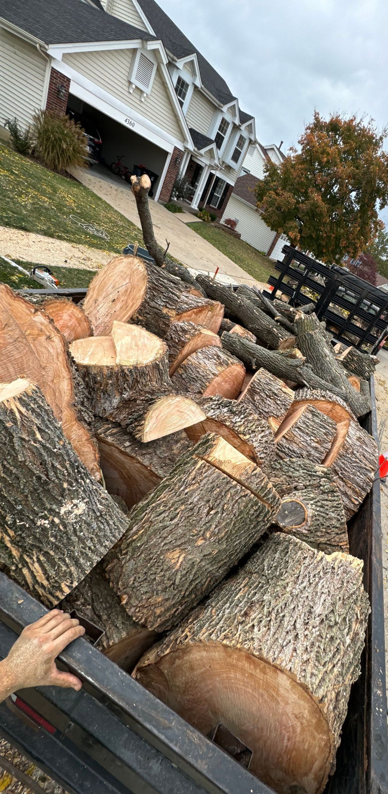 A truck filled with logs is parked on the side of the road.