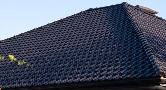 Dark blue tiled roof against a clear sky