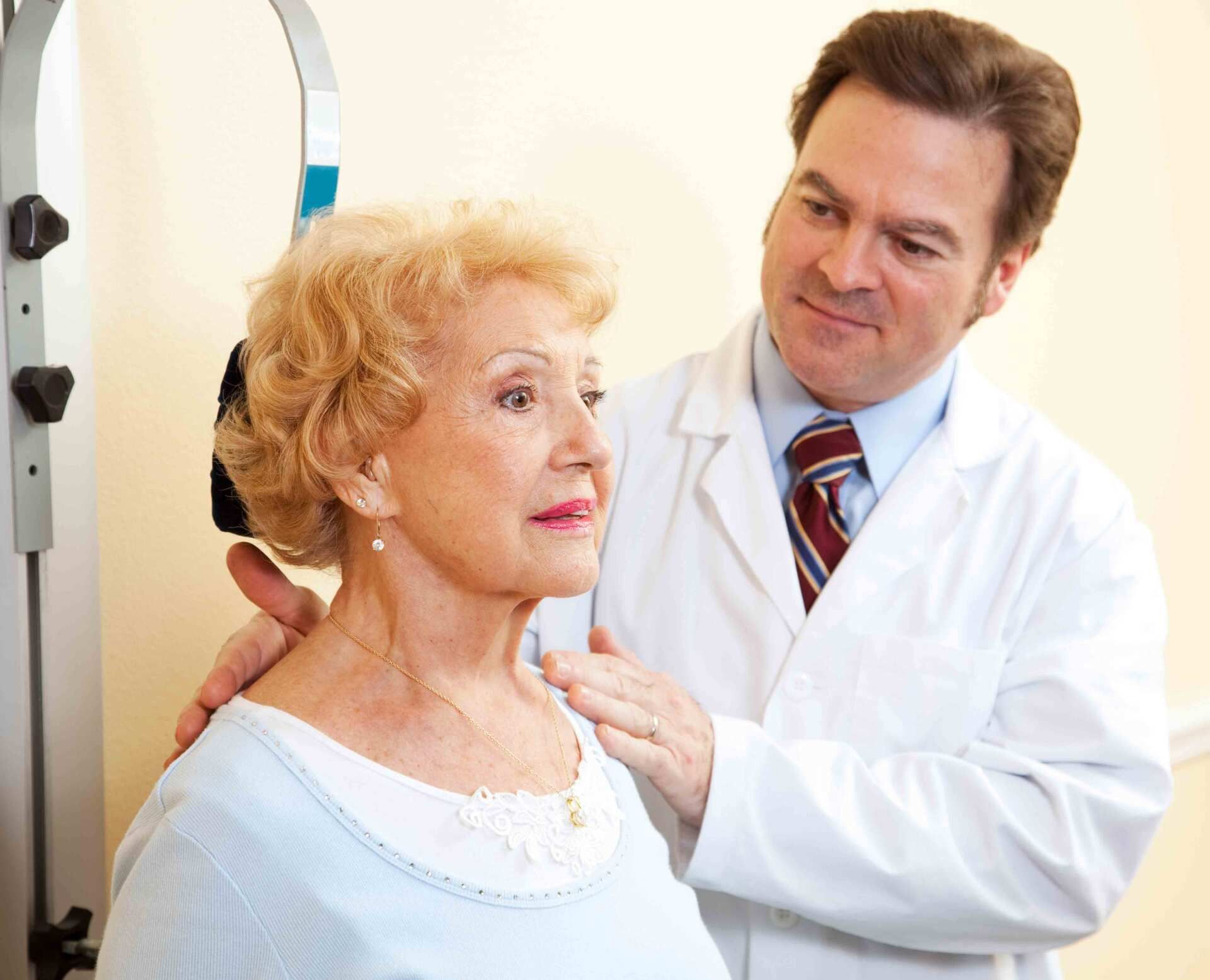 a doctor examines an older woman 's neck and shoulder