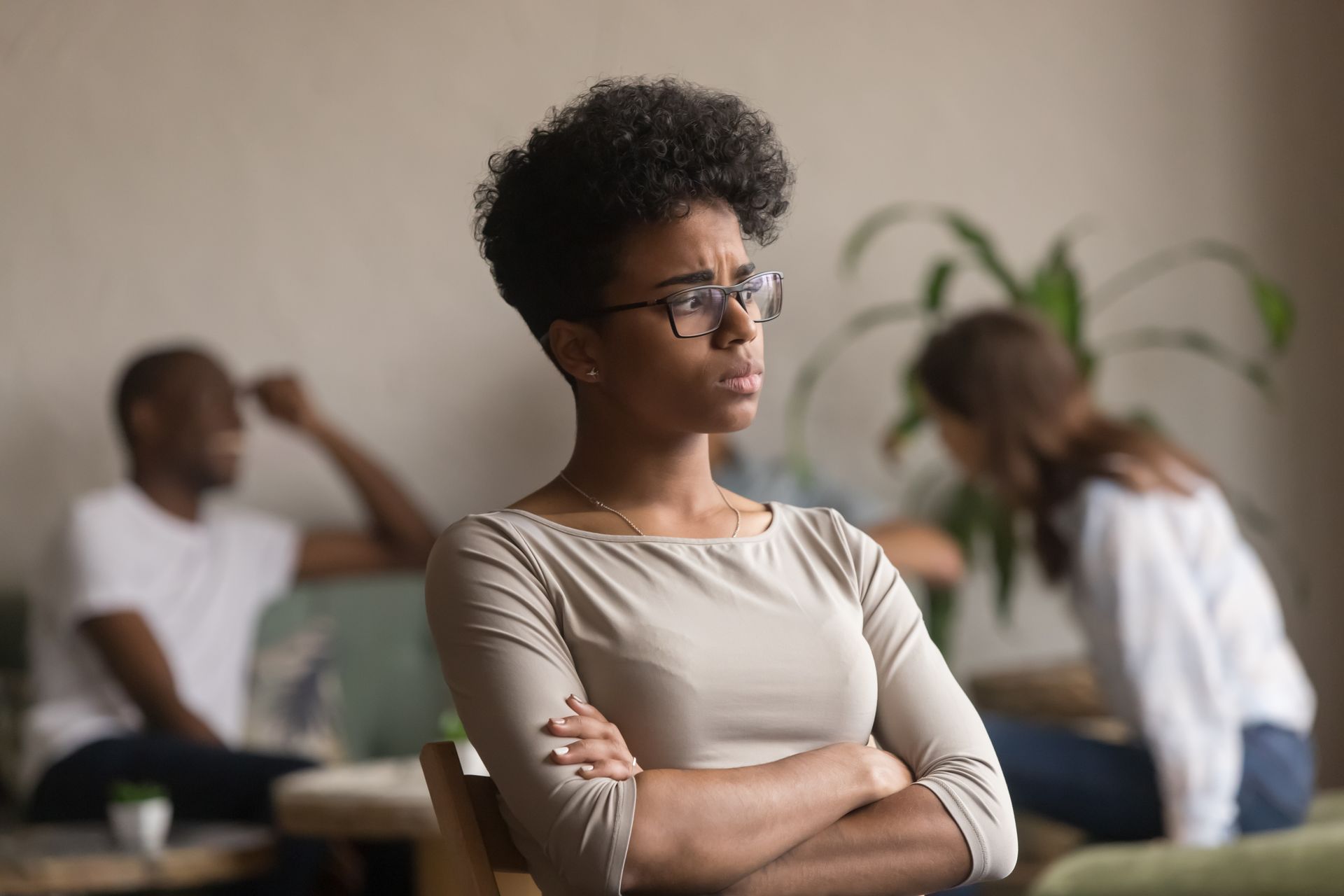 the woman sits with her arms crossed over her chest, she is feeling the symptoms of being emotionally overwhelmed