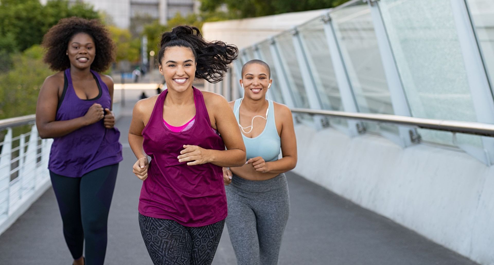 3 BiPOC women are running together on a bridge, they all have an understanding of the question why is it important to set realistic goals