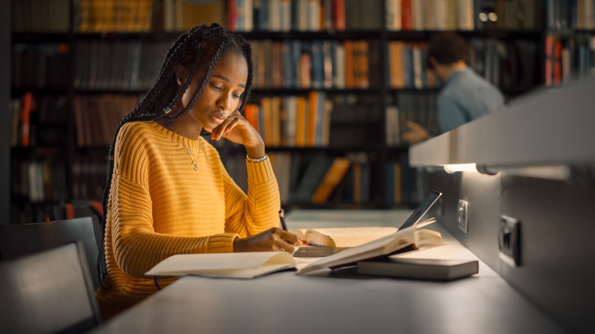 A young African American college student is in the library studying, she has concerns about goal setting for herself