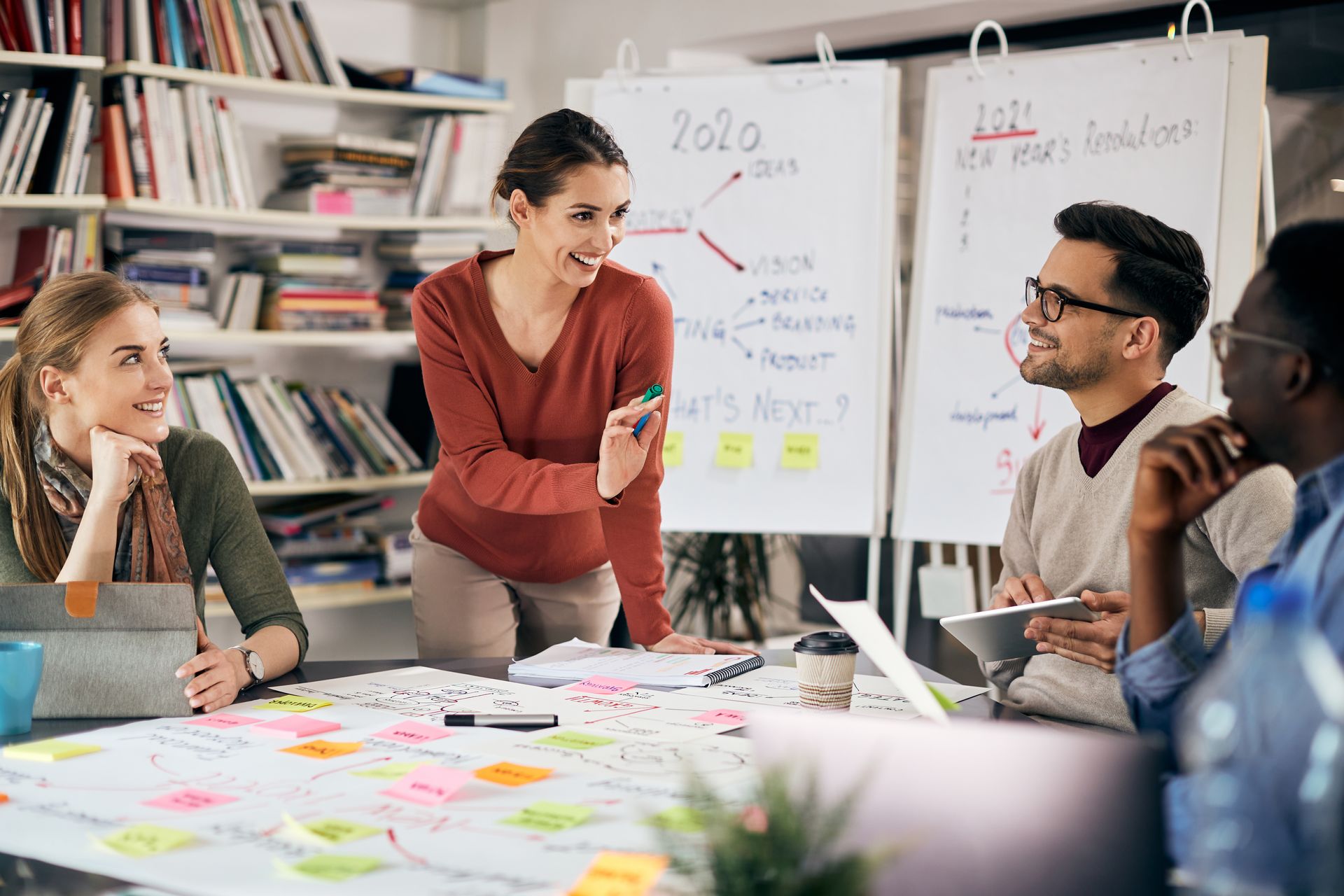 a woman in a red sweater displays mind mapping benefits to her coworkers