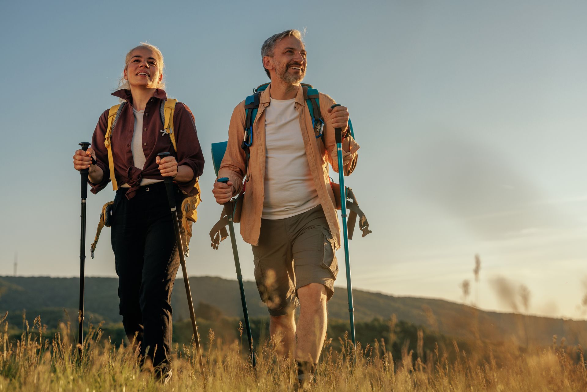 A man and a woman are hiking in a field contemplating perseverance vs persistence