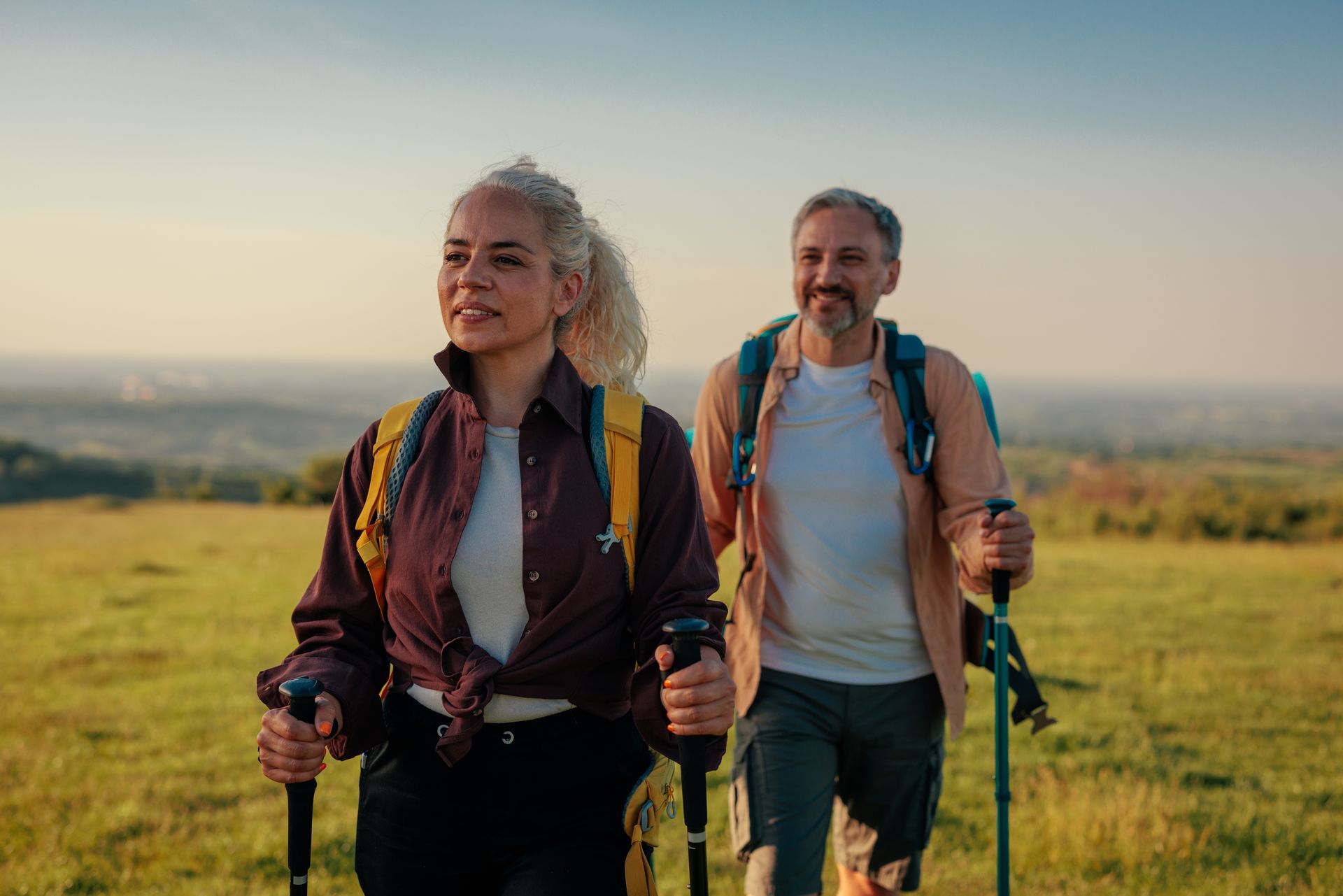 A man and a woman are hiking in a field contemplating perseverance vs persistence