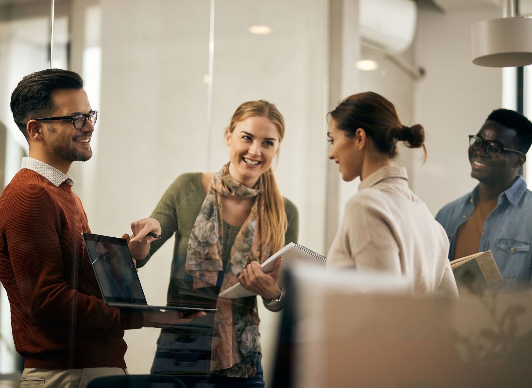 a woman in a green blouse and scarf shows her boss her and her team's collaboration and mind mapping benefits on a computer