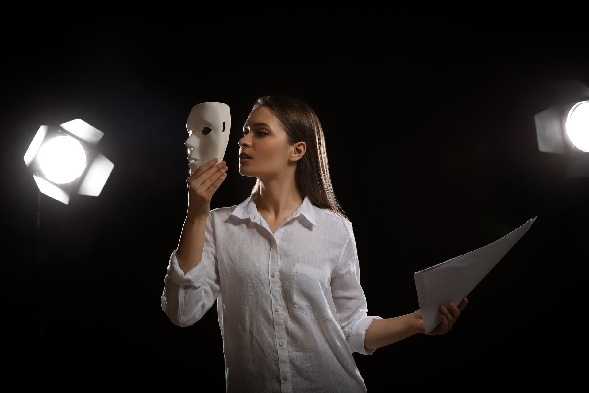 a woman is holding a mask and a piece of paper, rehearsing lines like an actor, trying to decide the difference between goals vs dreams