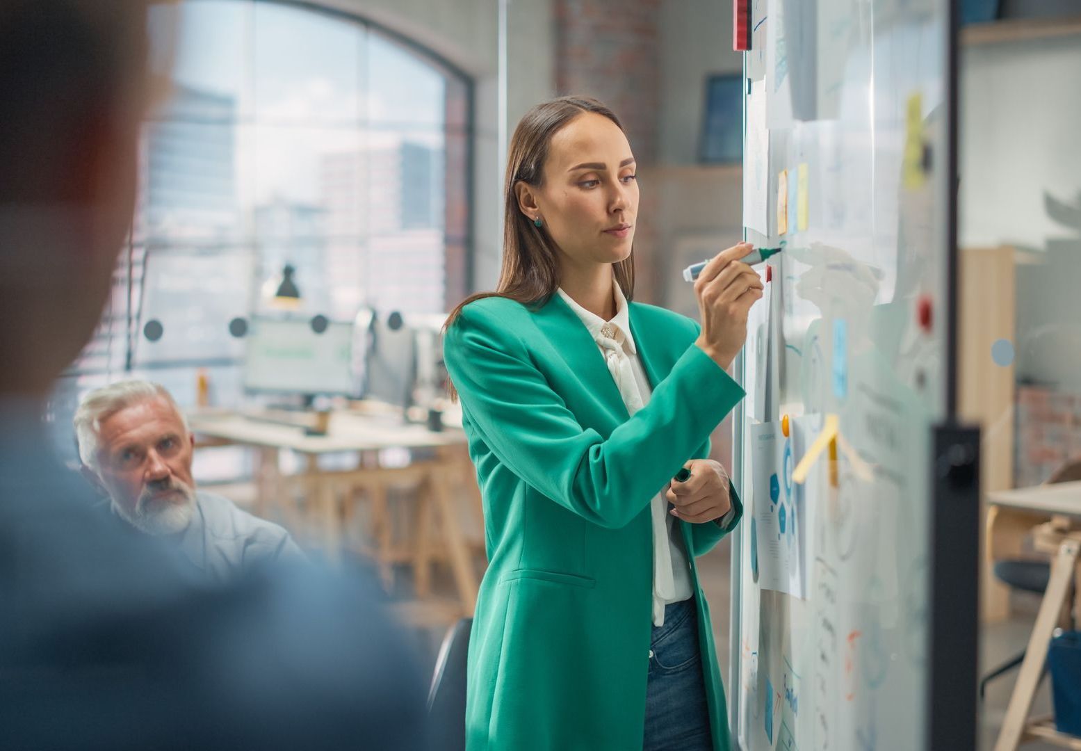 A young female executive gives a presentation after practicing strategies to achieve goals