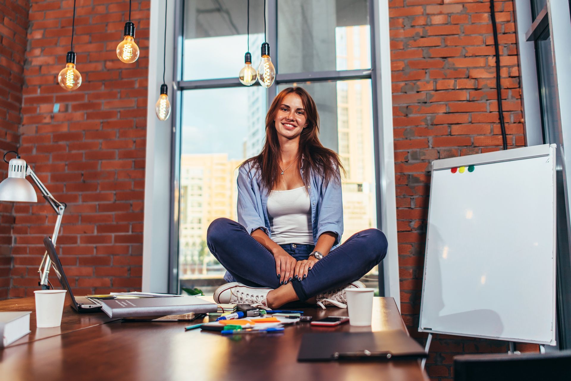 the young woman sitting in lotus pose on the desk, she has studied levels of emotional intelligence