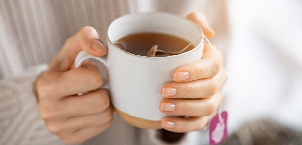 Woman holds cup of Hot Tea in Hands