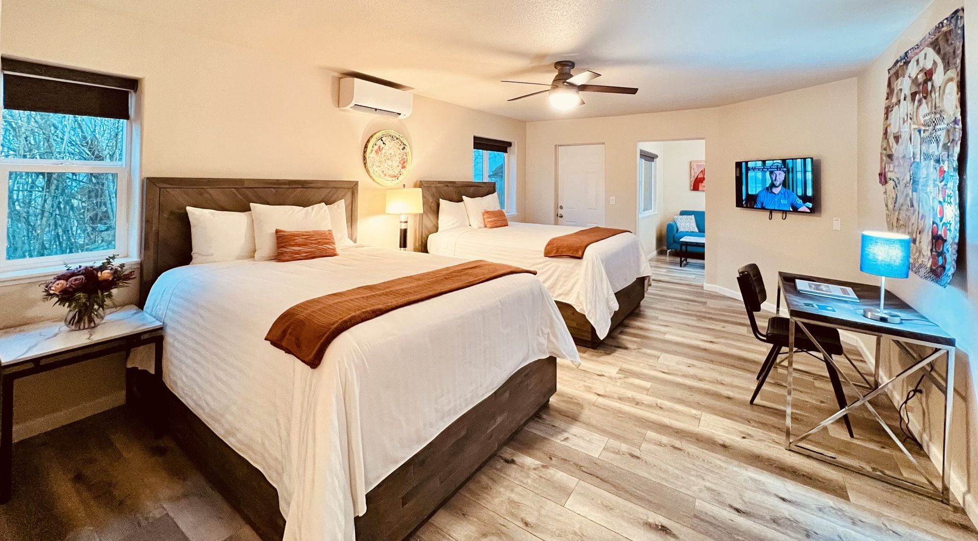 A hotel room with two beds , a desk and a television.