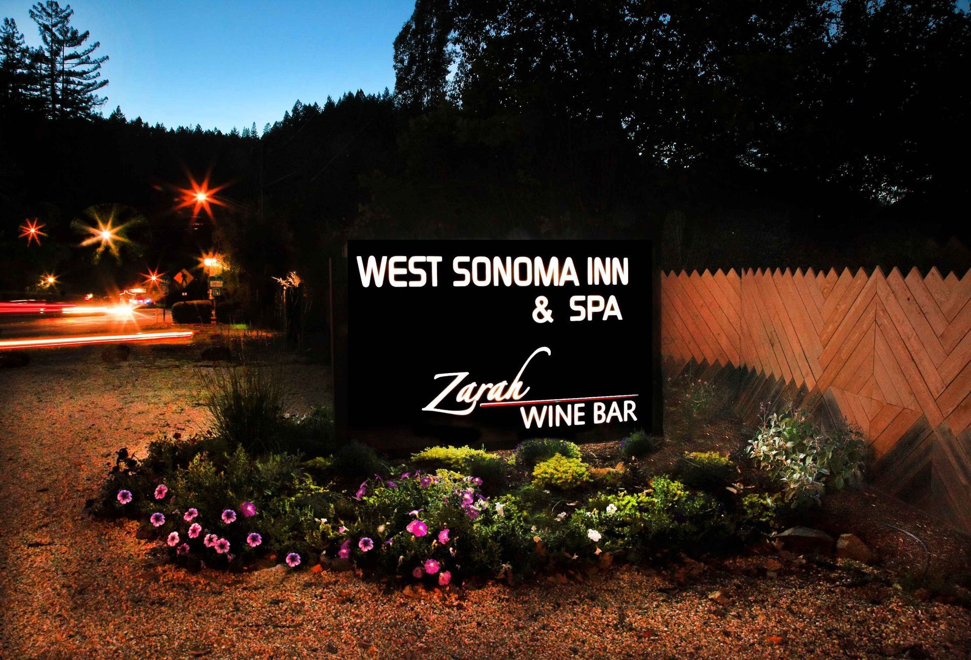 A sign for west sonoma inn and spa is lit up at night