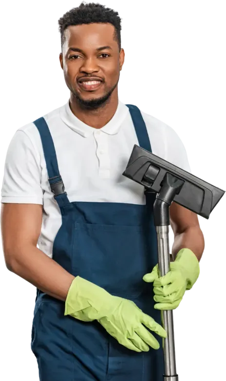 Smiling Black man in cleaning overalls, holding a vacuum wand, wearing green gloves.