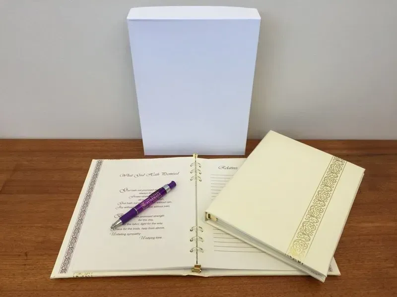 A purple pen sits on top of a book on a table
