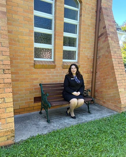 Two women standing on a balcony looking out at trees