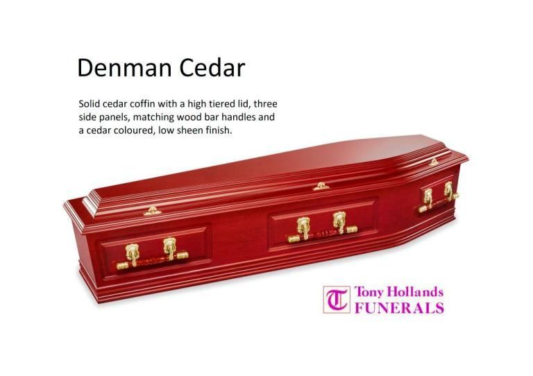 A red coffin with gold handles and a denman cedar finish is on a white background.