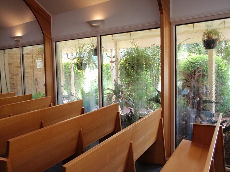 A church with a lot of windows and wooden benches