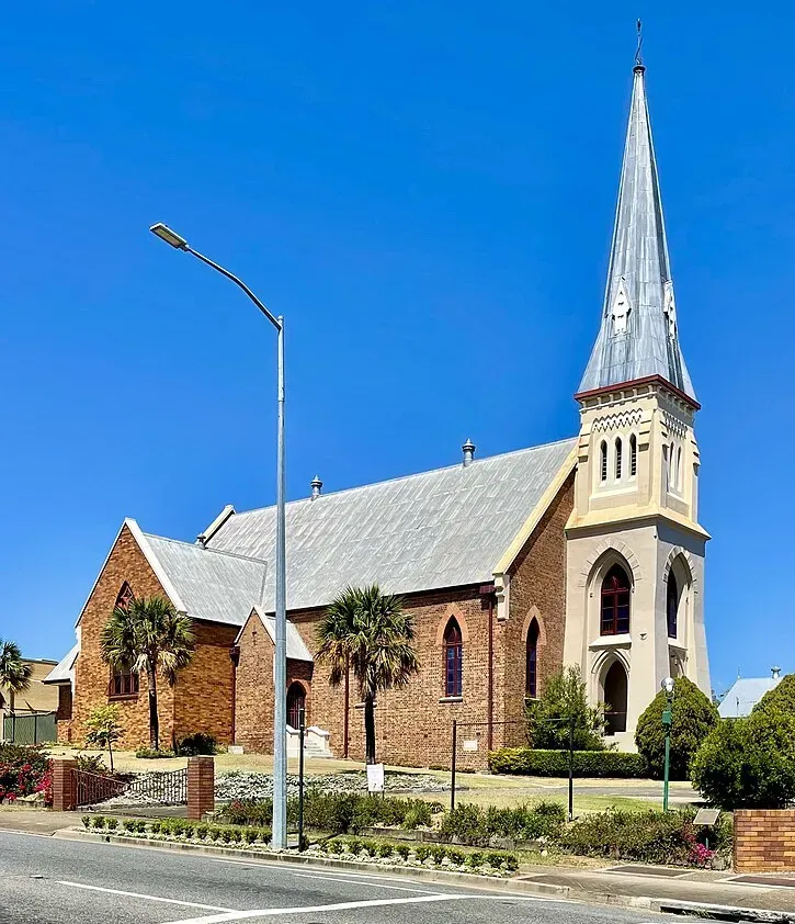 A church with a steeple and a street light in front of it