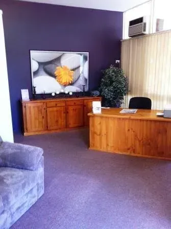 A living room with a couch , desk , and television.
