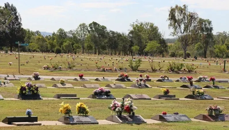 A cemetery with many graves and flowers on them