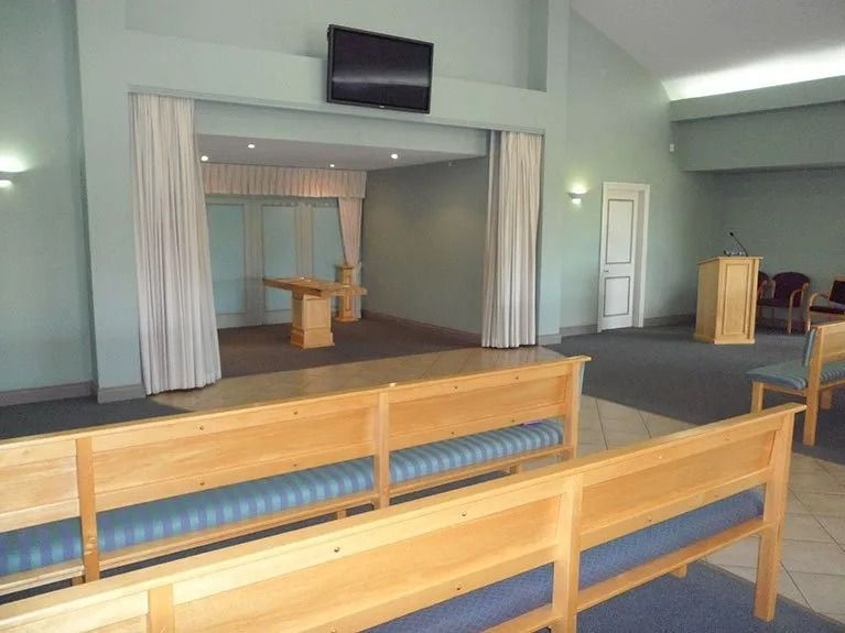 A church with wooden benches and a television on the wall