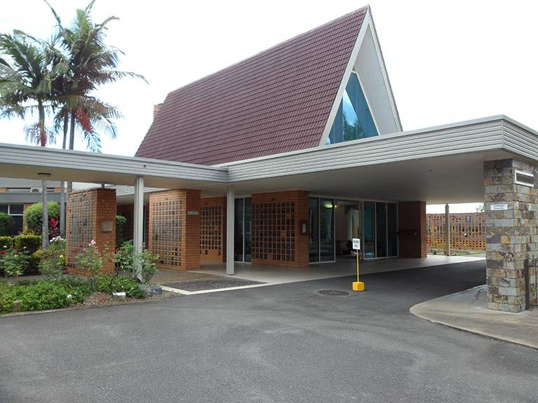 A large building with a red roof and a walkway leading to it