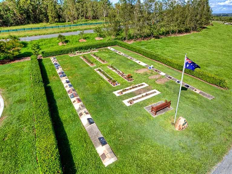 An aerial view of a cemetery with a flag in the middle of it.
