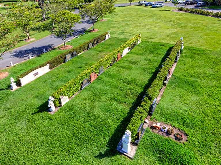 An aerial view of a cemetery with a lot of grass and trees.