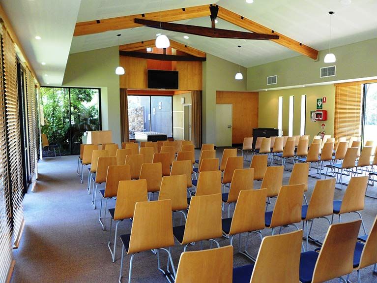 Rows of wooden chairs are lined up in a large room