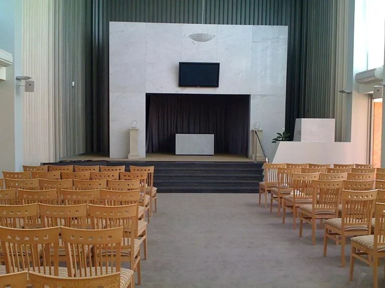 Rows of wooden chairs in front of a stage in a church