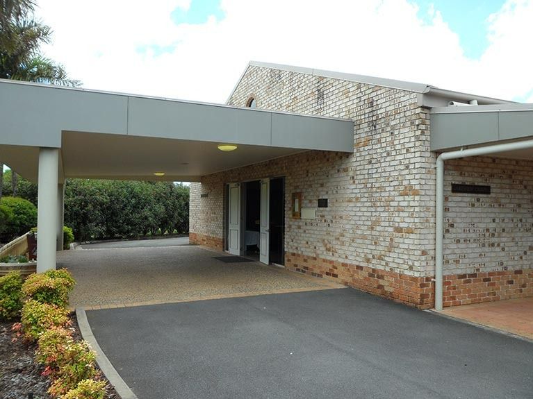 A brick building with a driveway leading to it