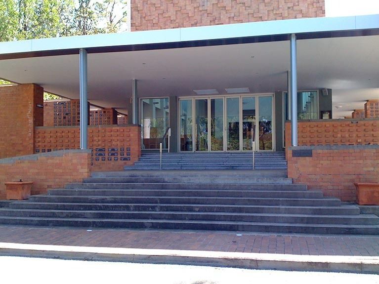 A brick building with stairs leading up to the entrance
