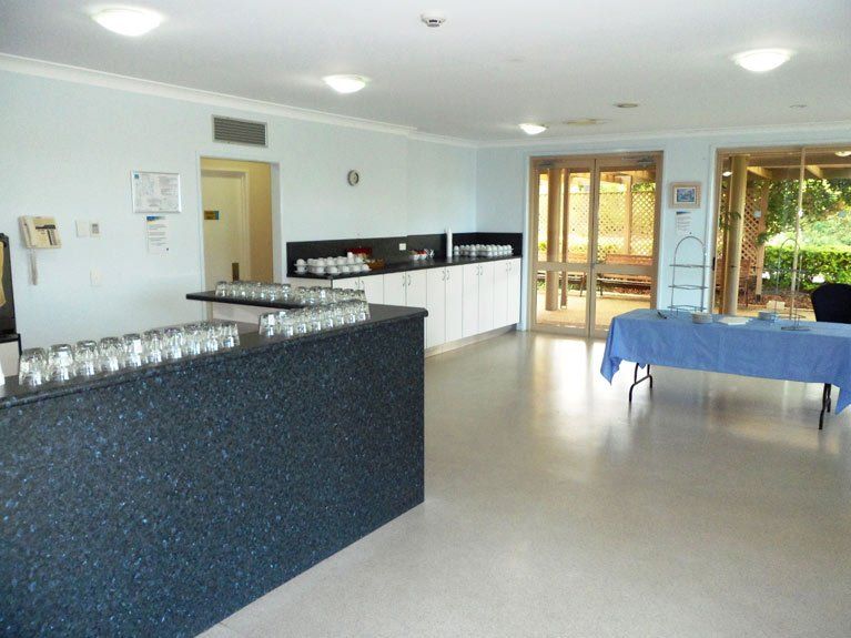 A room with a counter and a table with glasses on it