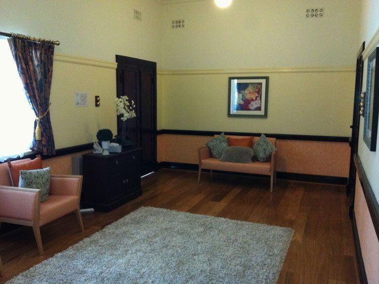 A living room with a couch and chairs and a rug