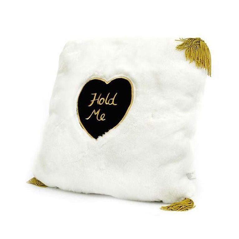 A white pillow with a black heart that says hold me