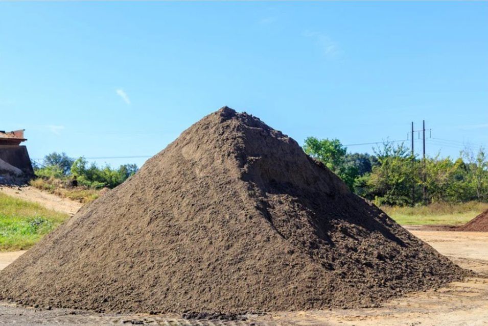 A large pile of dirt is sitting in a field.