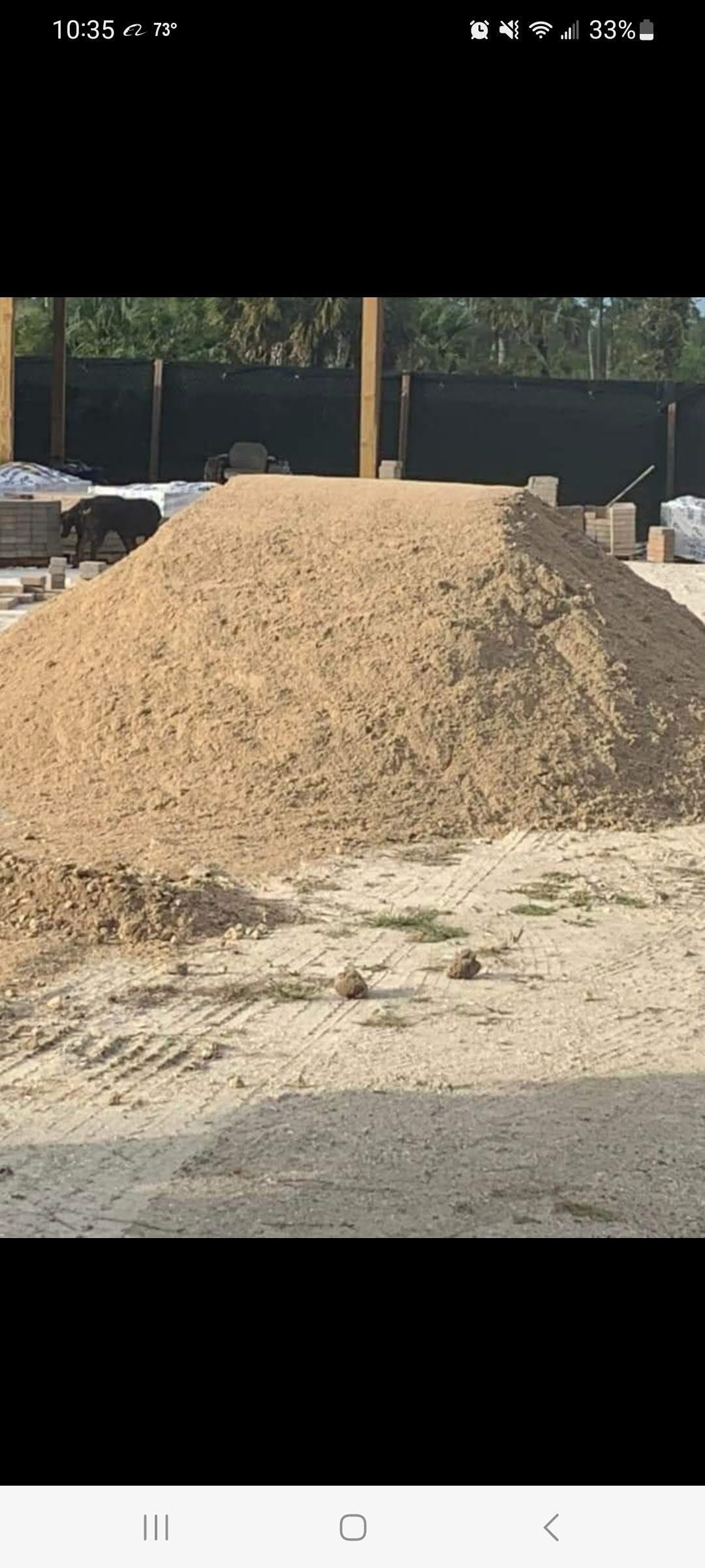 A large pile of dirt is sitting on top of a dirt field.