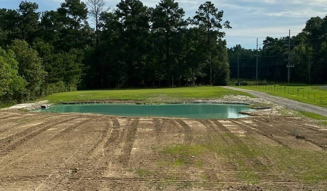 There is a large body of water in the middle of a field.
