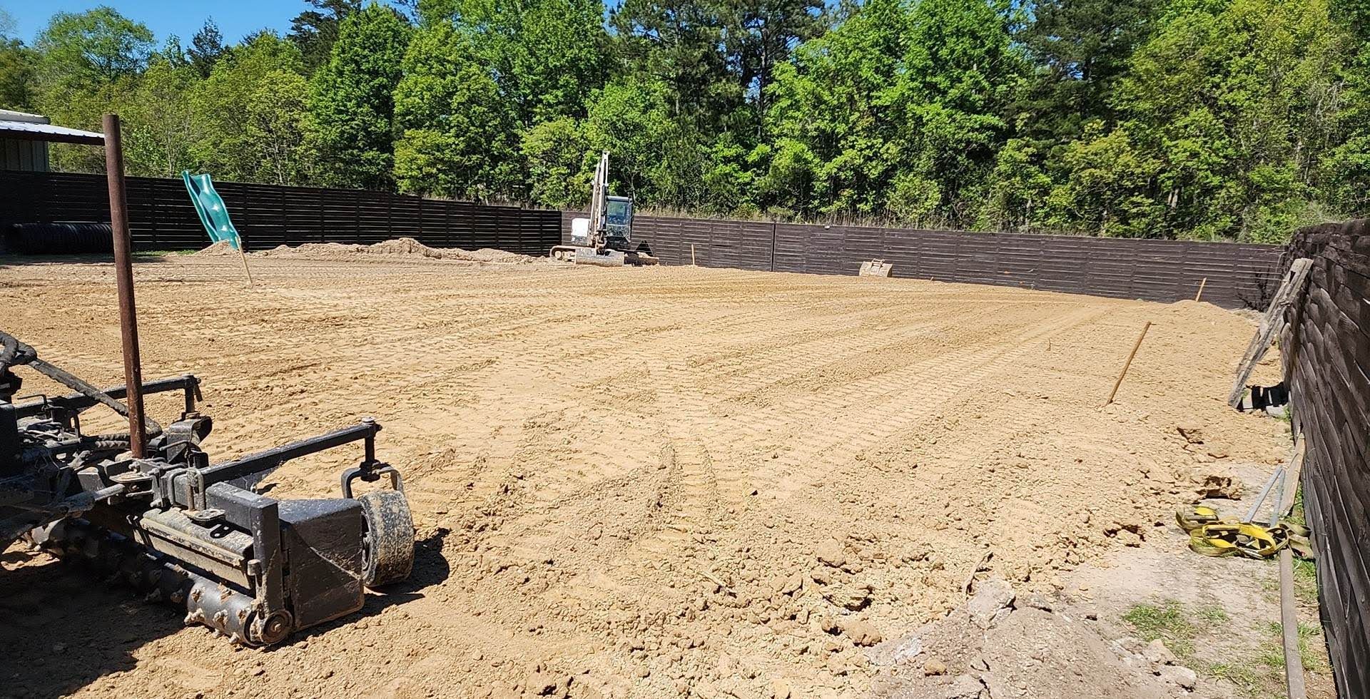 A tractor is sitting in the middle of a dirt field.