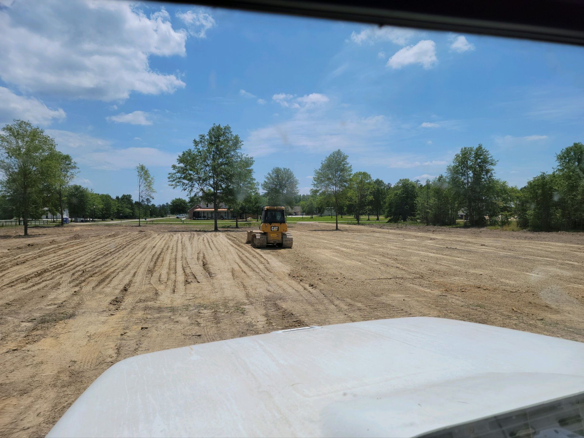A bulldozer is driving through a dirt field.