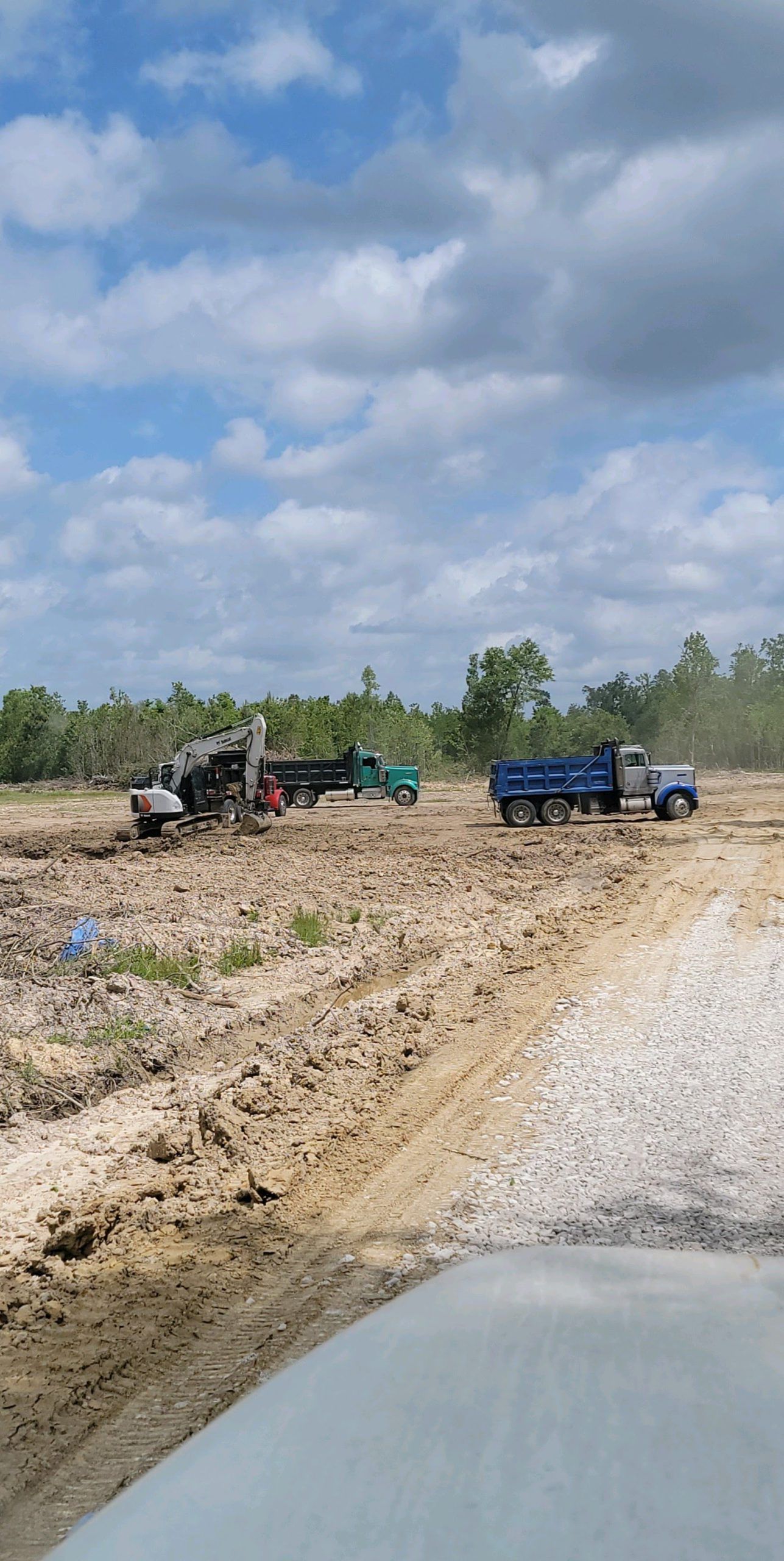 A truck is parked in the middle of a dirt road.
