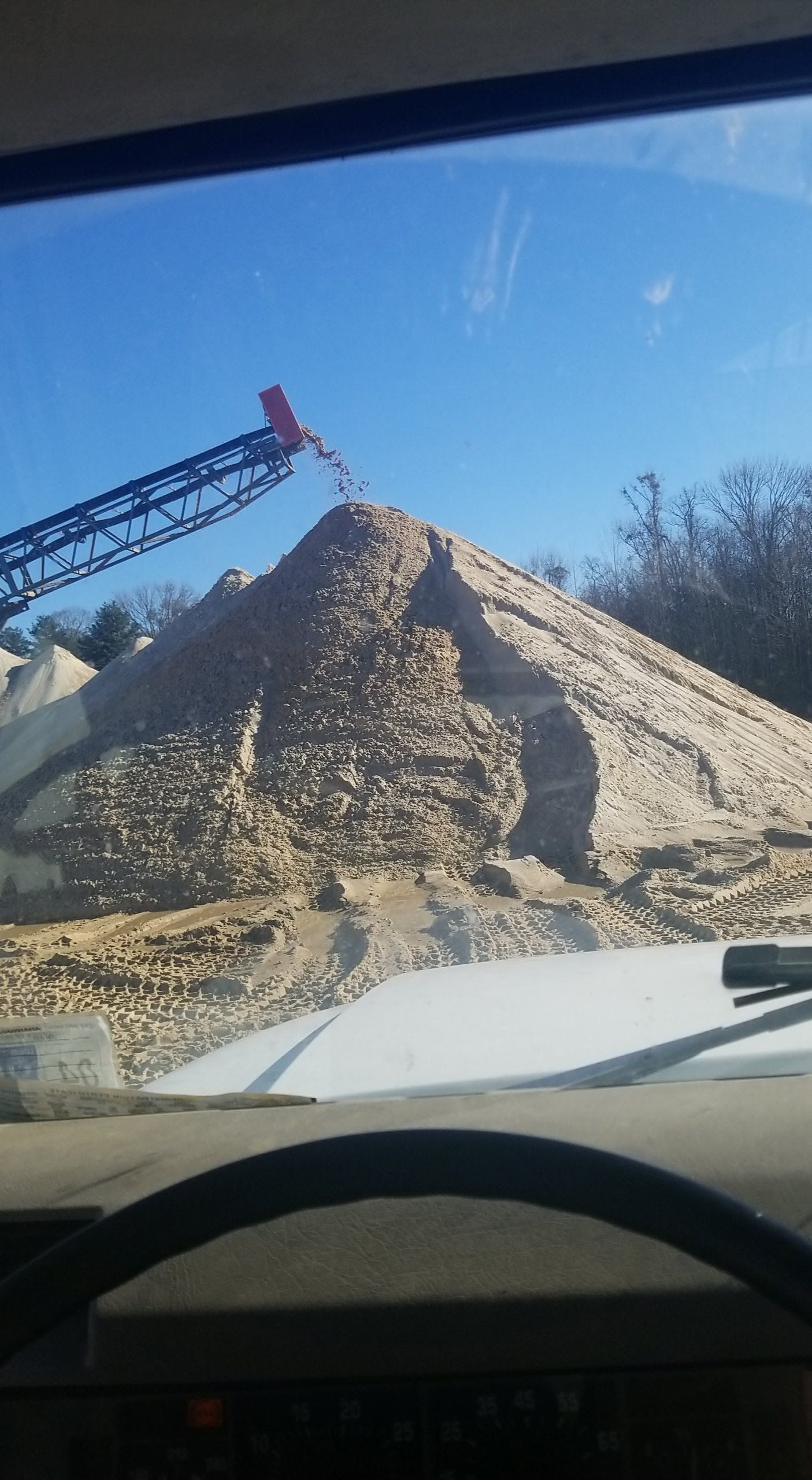 A view of a pile of rocks from inside a car.