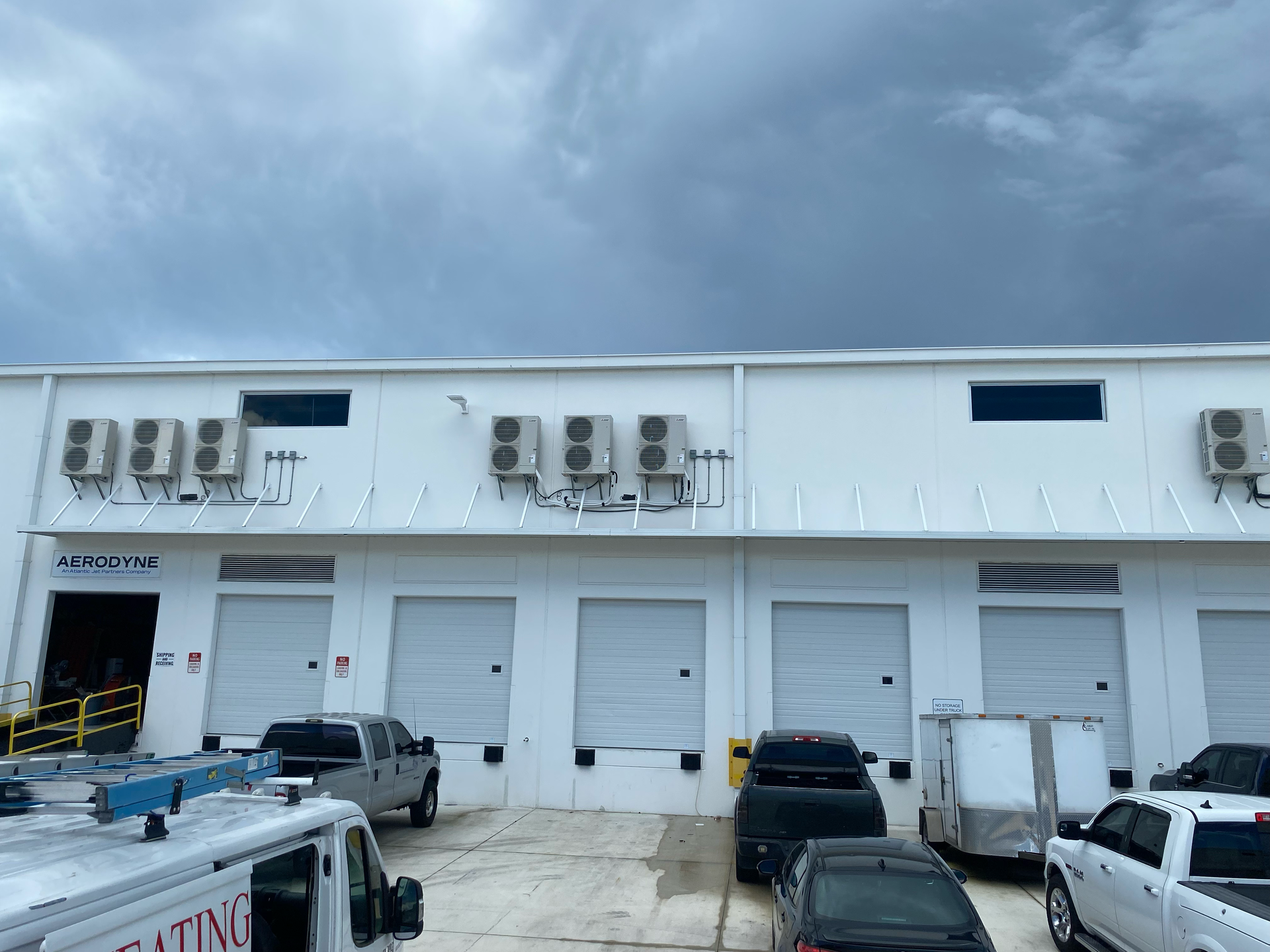 Mintz Heating & Cooling service vehicles outside a commercial warehouse in Fort Lauderdale, FL
