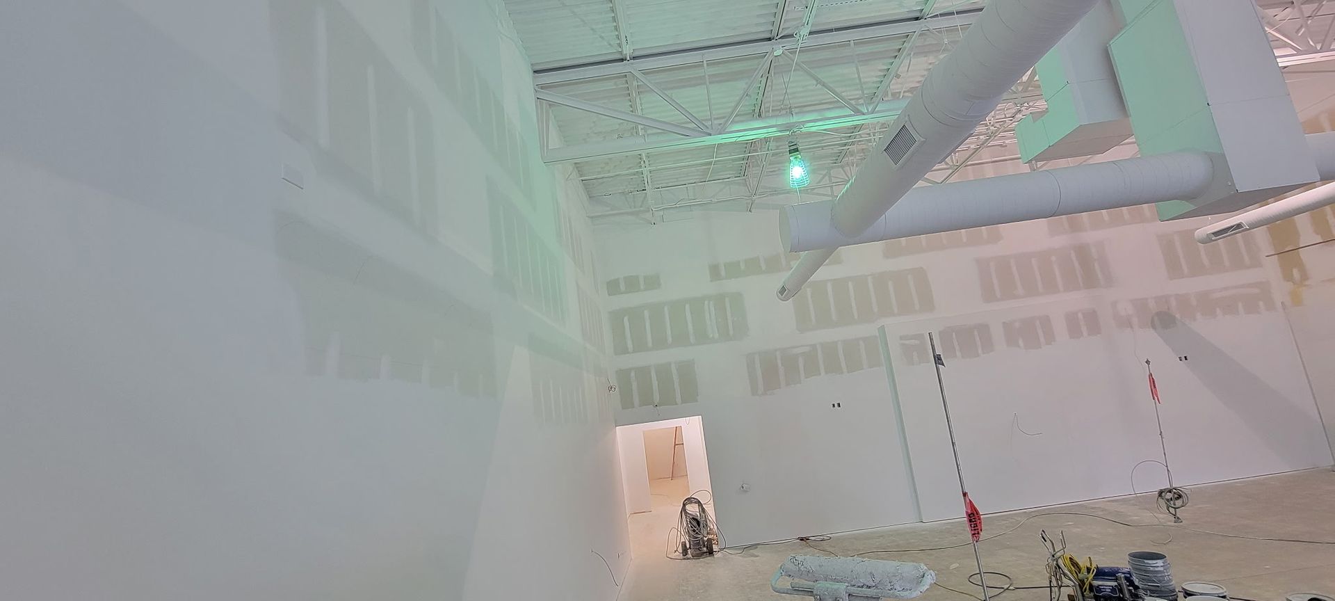 Ladder holding freshly painted trim in a room with partially painted walls.