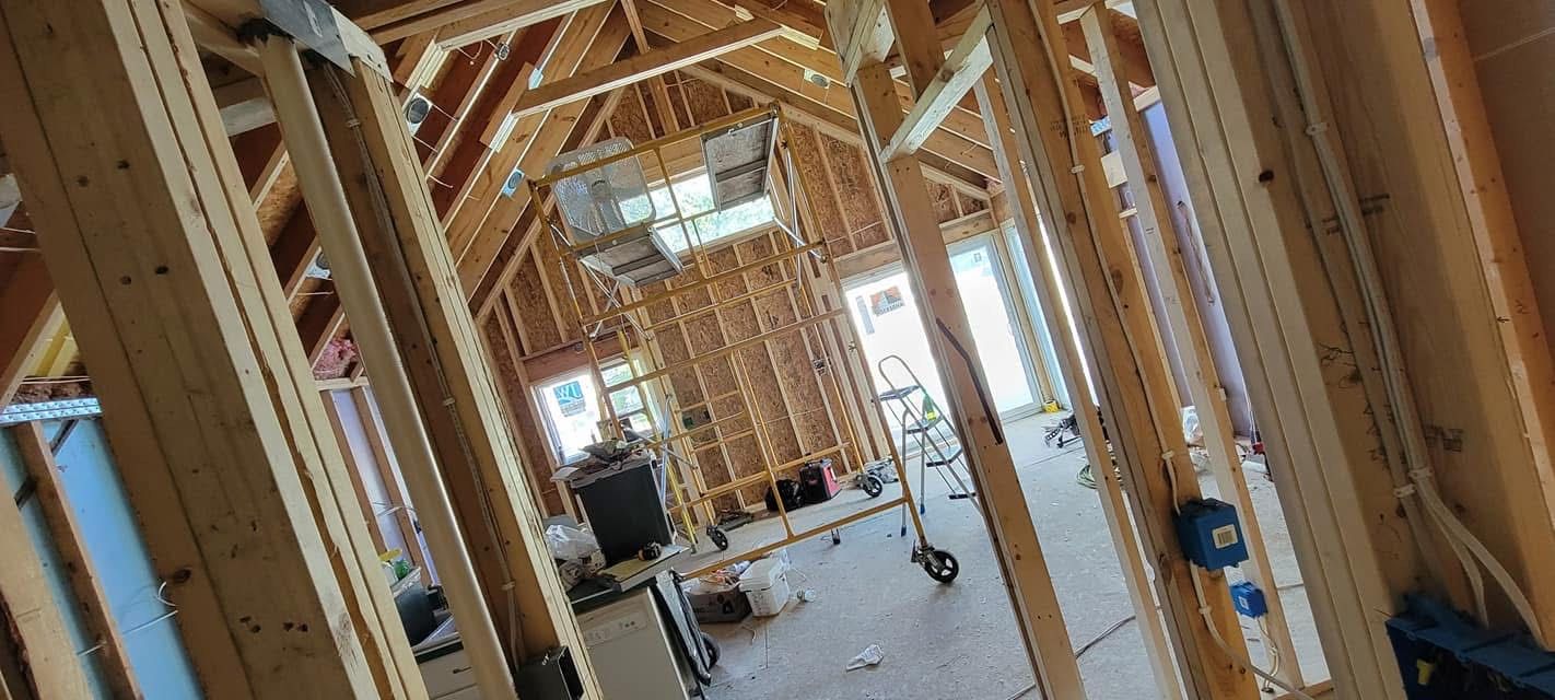 Interior view of a building under construction, framed with wooden beams.