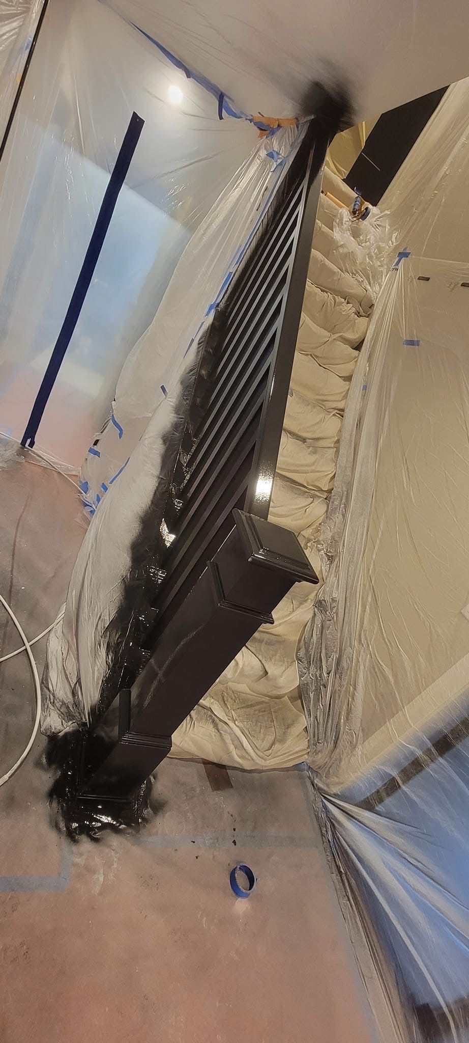 Dark, textured material along a wall, possibly a gutter or drain, with light-colored surface surrounding.