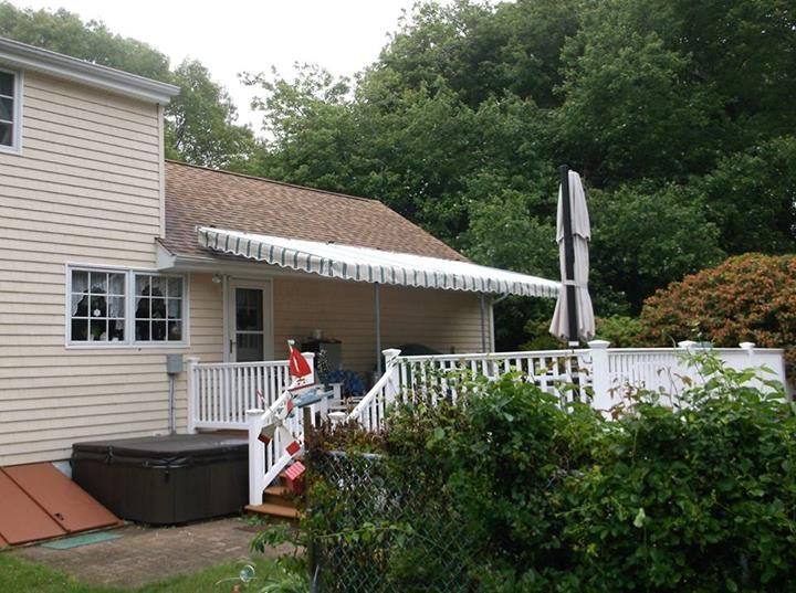 A house with a deck and a hot tub in the backyard