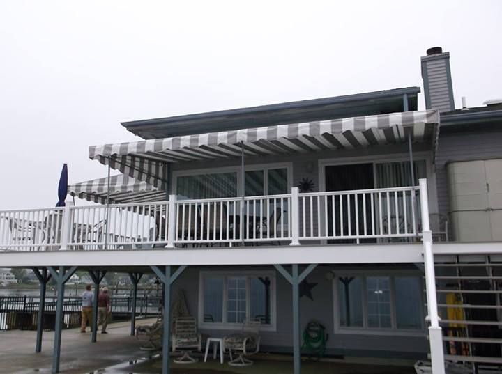 A house with a striped awning on the deck