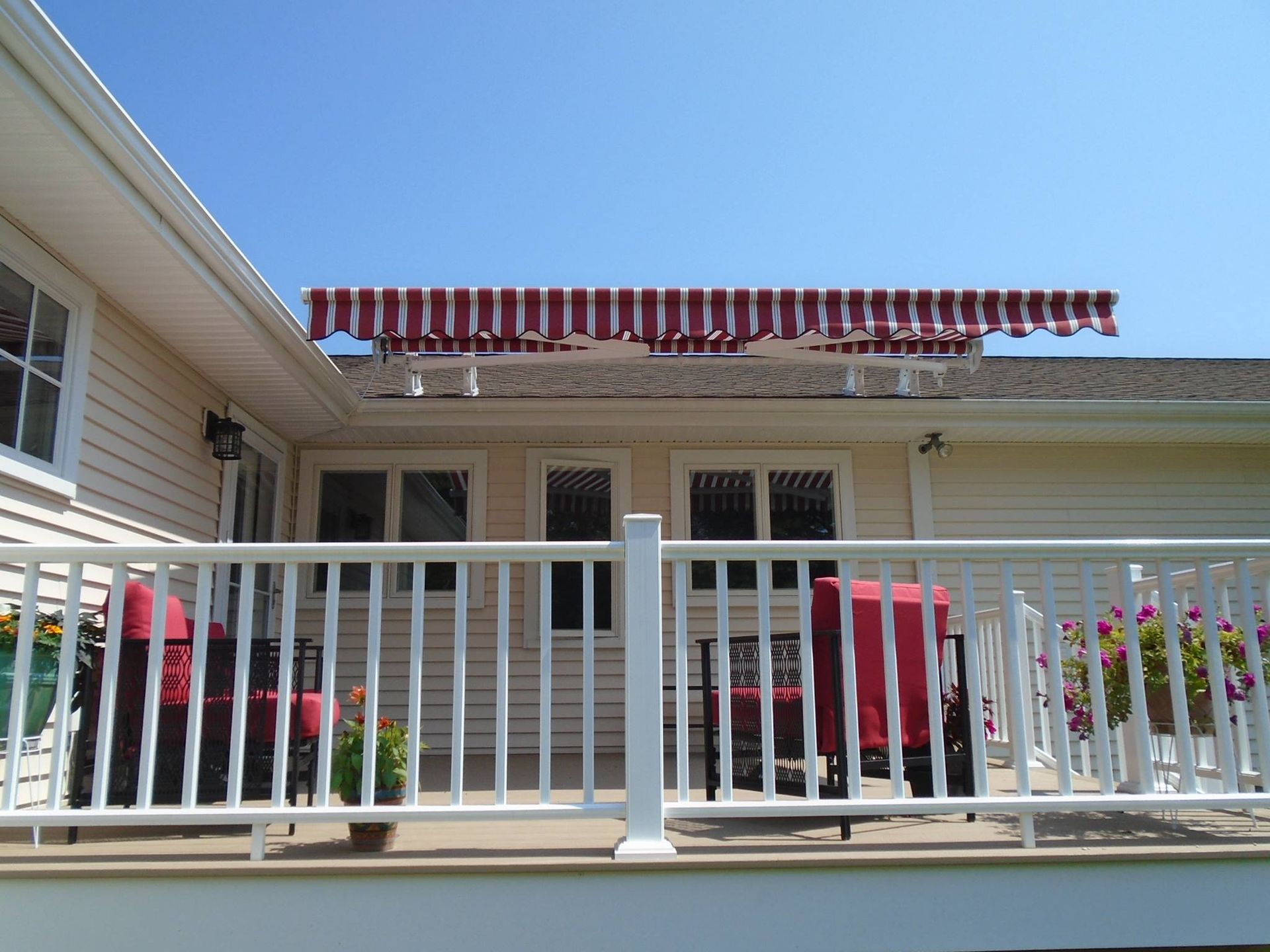 A white deck with a red awning on top of it