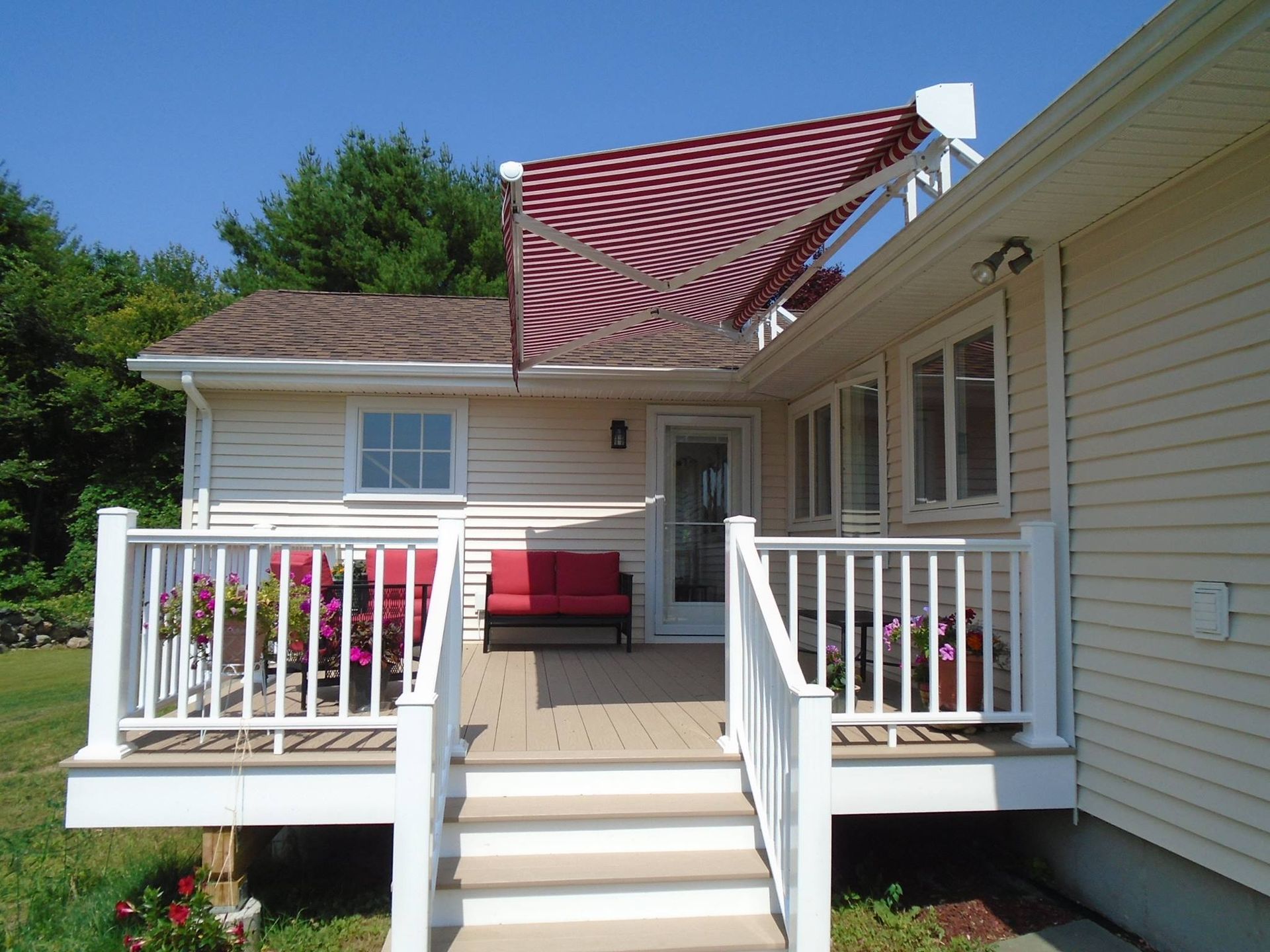 A white house with a red and white awning on the roof